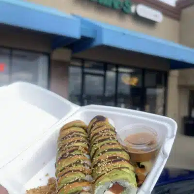 Sushi in to-go tray featuring the Khin's Sushi sign
