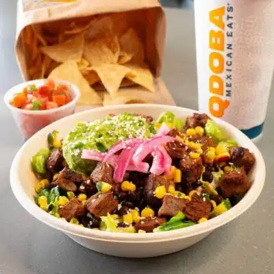 Closeup of bowl from Qdoba with chips and a drink