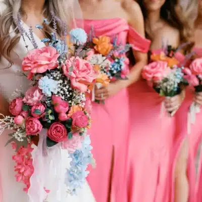Pink, blue, and orange florals of bride and bridal party at I Do at the Barn