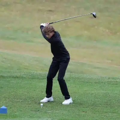 Male golfer swinging at Gibson Bay