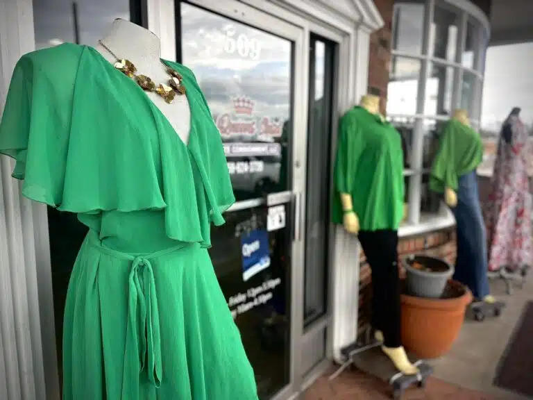 Closeup of green outfits outside The Queens Closet