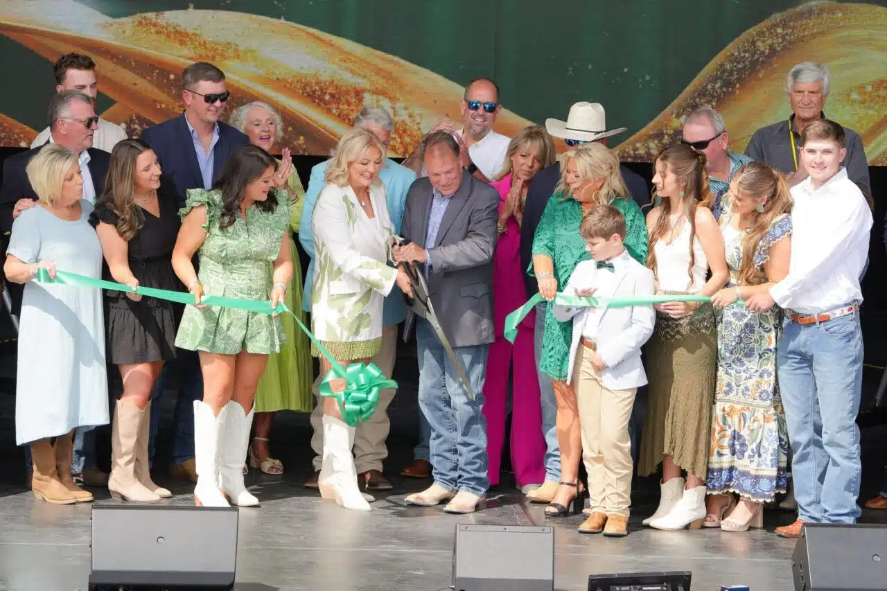 Ed and Becky Chenault are surrounded by their family as they cut the ribbon officially marking the grand opening of The Vine at Chenault Vineyards.