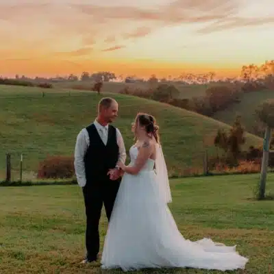 Bride and Groom standing in the vineyard at sunset