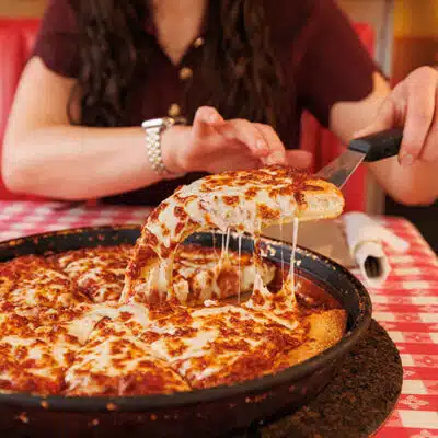 Patron pulling a slice of pizza from Pizza Hut