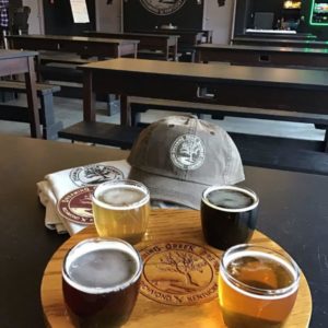 Tasting at Dreaming Creek Brewery with merchandise behind them