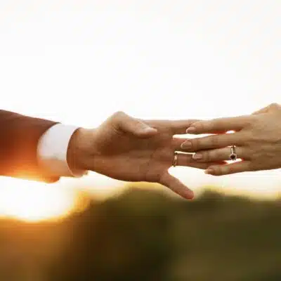 Bride and groom grazing hands during golden hour at The Lancaster at Silver Creek