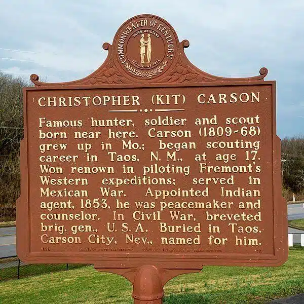 Christopher (Kit) Carson birthplace marker sign reads: Famous hunter, soldier, and scout born near here. Carson (1809-68) grew up in Missouri; began scouting career in Taos, New Mexico, at age 17. Won renown in piloting Fremont's Western expeditions; served in Mexican War. Appointed Indian agent, 1853, he was peacemaker and counselor. In Civil War, breveted br. gen., U.S.A. Buried in Taos. Carson City, Nevada is named for him.