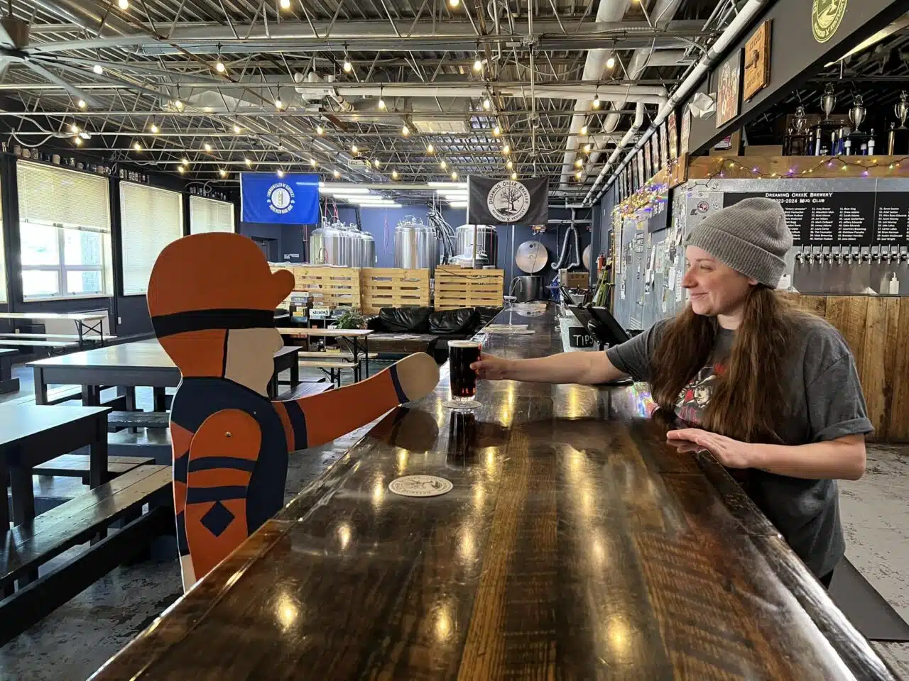 Living Like a Local featured image of painted jockey enjoying a drink at Dreaming Creek Brewery