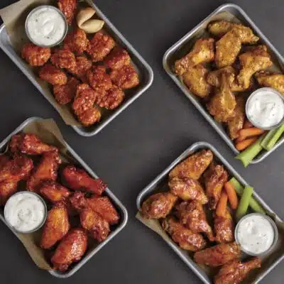 Aerial view of four trays of chicken from Buffalo Wild Wings