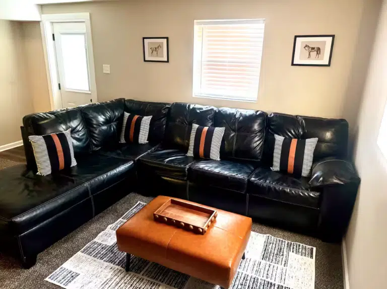 Living room of a short-term rental, featuring a L-shaped couch and coffee table