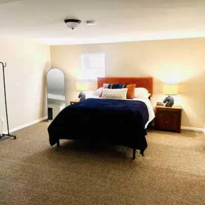 Queen size bed and ample space in the bedroom of this short-term rental