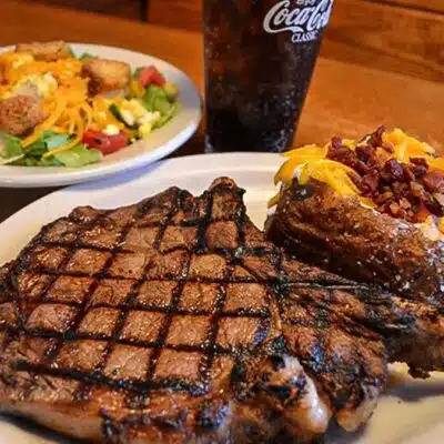 Steak with loaded baked potato and salad at Texas Roadhouse