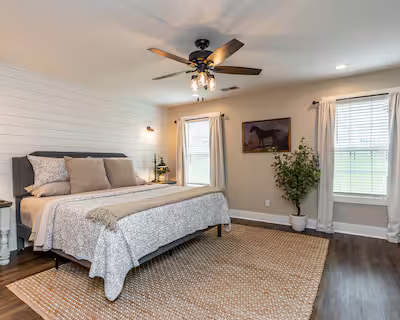 Primary bedroom of short-term rental with airy feel