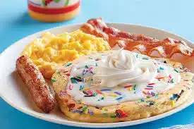 Funfetti pancakes from IHOP with sausage links, eggs, and bacon